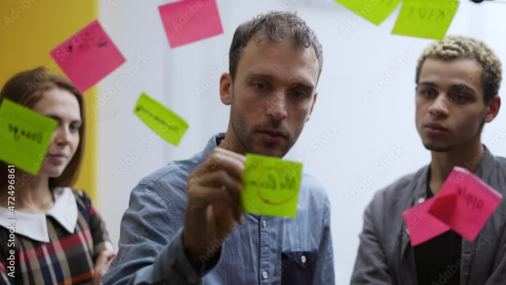 Diverse group of finance office worker having corporate training and using glass wall with stickers Diverse group of finance office worker having corporate training and using glass wall with stickers
