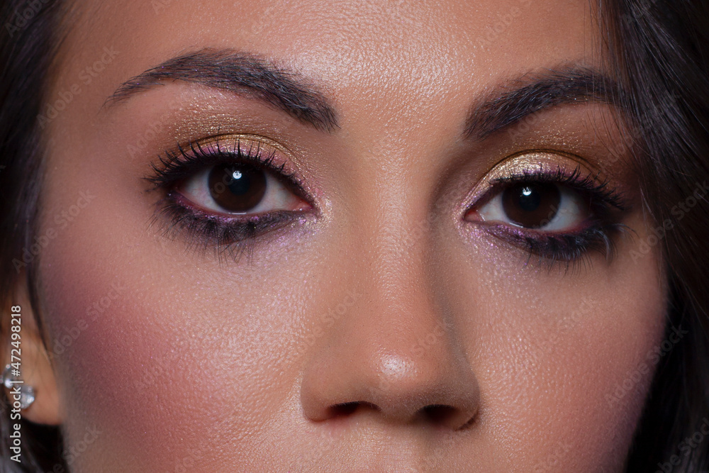 Naklejka premium Elegance close-up female eye with light pink eyeshadow. Macro shot of part of the face of a beautiful woman. Wellness, cosmetics and makeup. smooth beautiful eyebrows and eyelashes