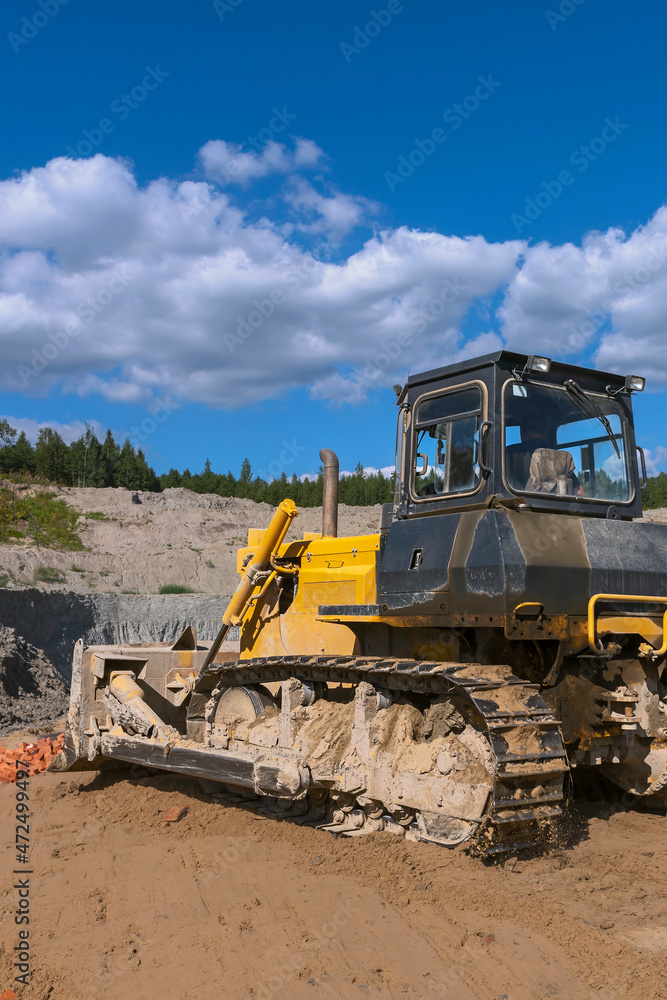 the process of leveling the soil with a modern bulldozer during the construction of a dirt road