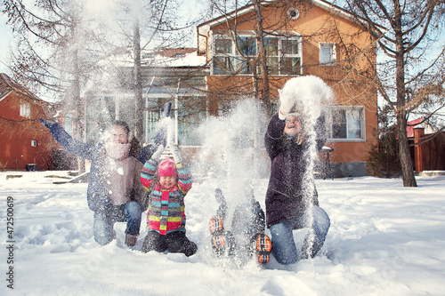 family playing with snow in the winter outdoors