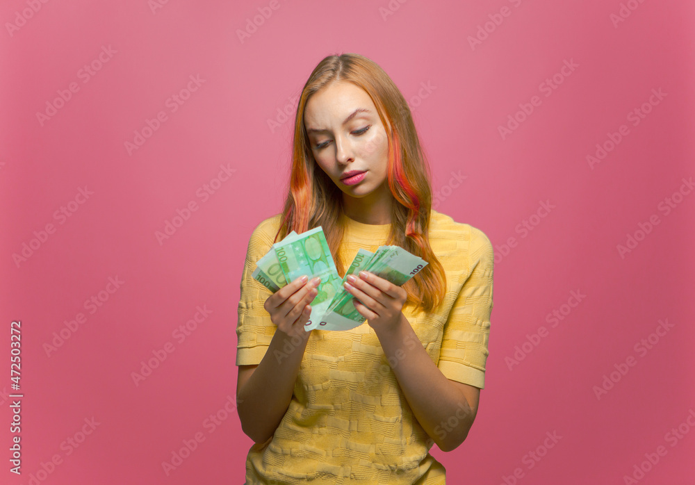 Pensive young girl counting cash thinking about finding money for paying bills. Financial problems and bankruptcy Pensive young girl counting cash thinking about finding money for paying bills. Financial problems and bankruptcy