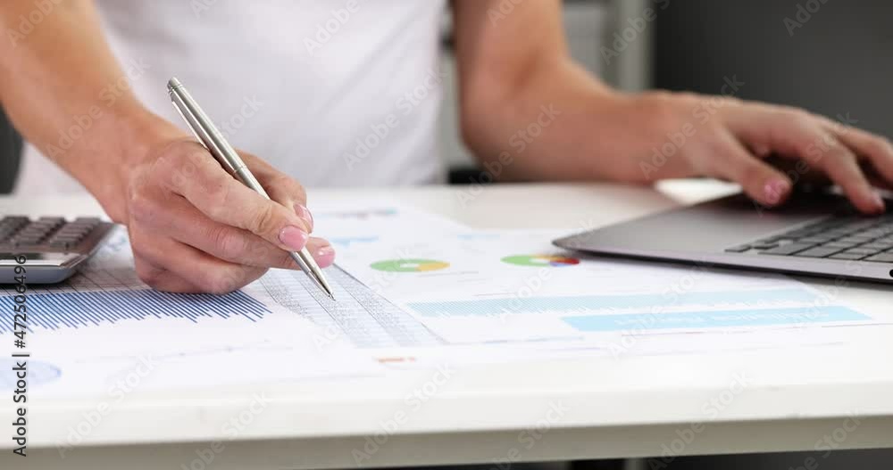 Businesswoman works on laptop and studies financial reports Businesswoman works on laptop and studies financial reports