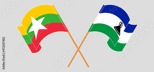 Crossed and waving flags of Myanmar and Kingdom of Lesotho