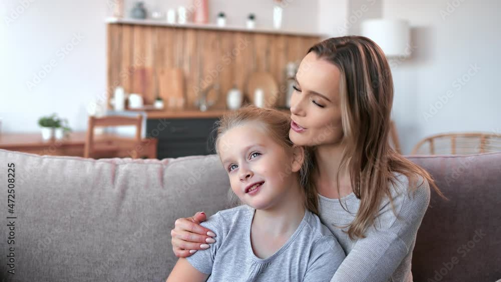 Happy young blonde mother and cute little daughter hugging relaxing talking spending time together Happy young blonde mother and cute little daughter hugging relaxing talking spending time together