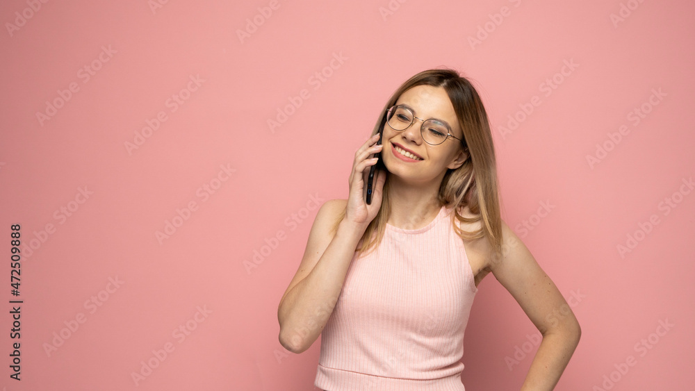 Young blonde woman over isolated pink background sending a message with the mobile. Young blonde woman over isolated pink background sending a message with the mobile.