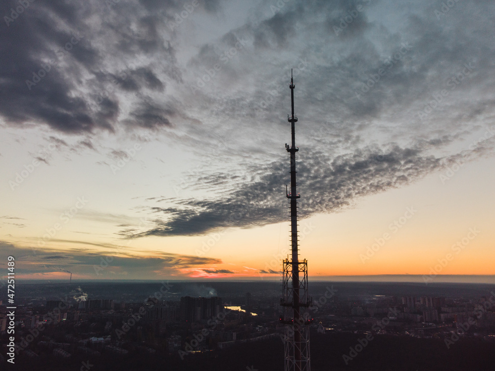 Aerial sunset evening city view on dark telecommunication tower antenna silhouette and scenic cloudy sky. Kharkiv, Ukraine Aerial sunset evening city view on dark telecommunication tower antenna silhouette and scenic cloudy sky. Kharkiv, Ukraine