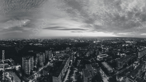 Night lights on streets of residential district and moody cloudy sky. Aerial grayscale sunset scenic panorama on Kharkiv city  Pavlove pole