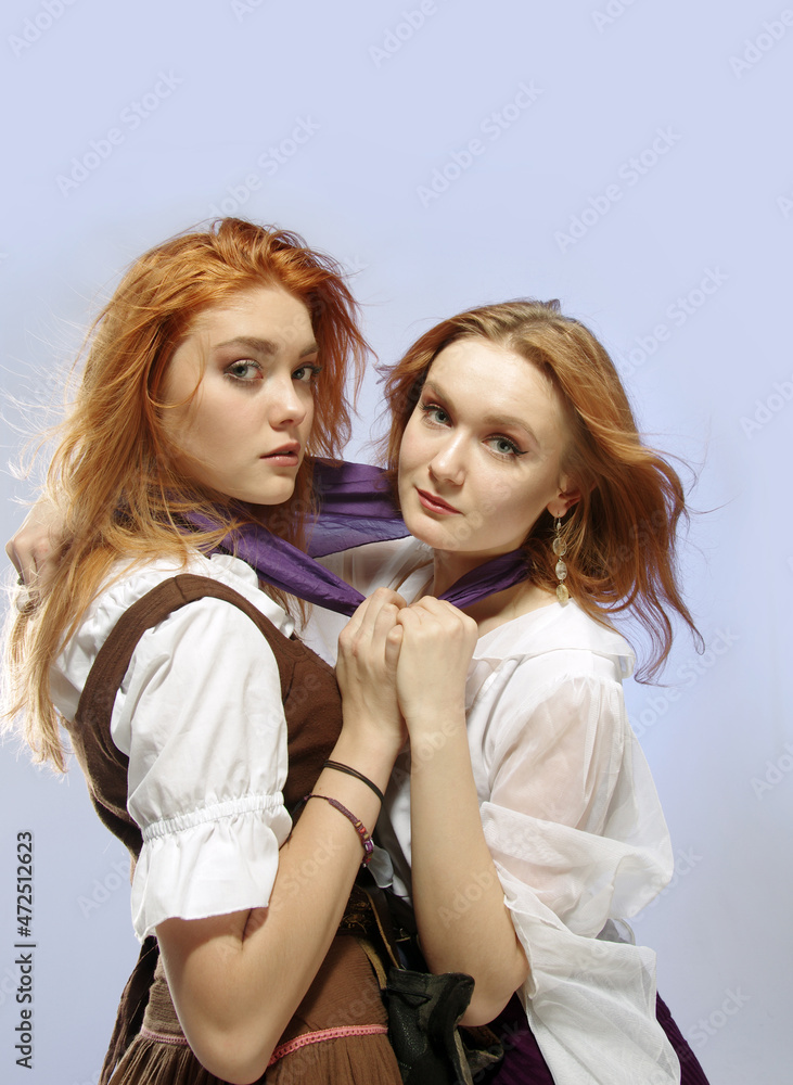 Photoshoot with two red-haired girls - sisters in the studio on a blue background. Photoshoot with two red-haired girls - sisters in the studio on a blue background.