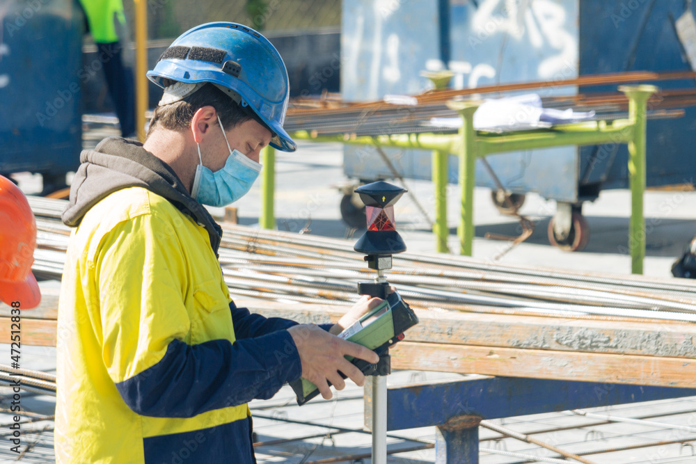 surveyor working on site on a deck with a face mask during pandemic lockdown Australia Sydney surveyor working on site on a deck with a face mask during pandemic lockdown Australia Sydney