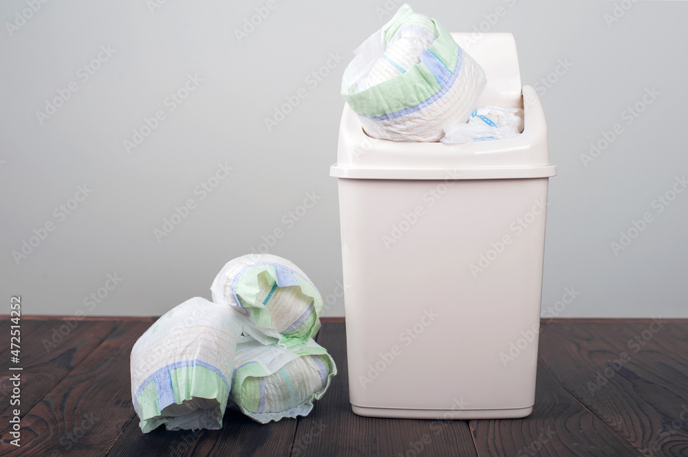 Diapers waste, dirty diapers in garbage pail Disposing of used baby