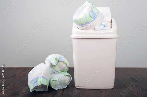 Diapers waste, dirty diapers in garbage pail Disposing of used baby nappies. Environmental Impact of Disposable Diapers. Pollution of the environment, soil and water.