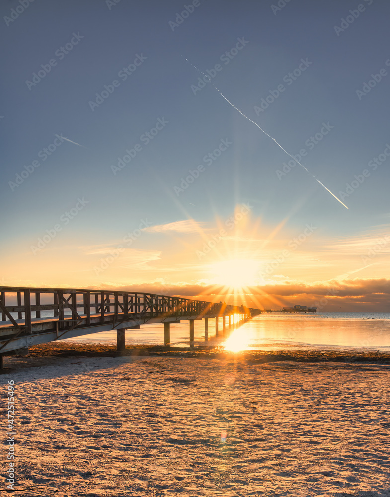 Obraz premium Wooden pier with sunstar on Bjarred beach in south Sweden.