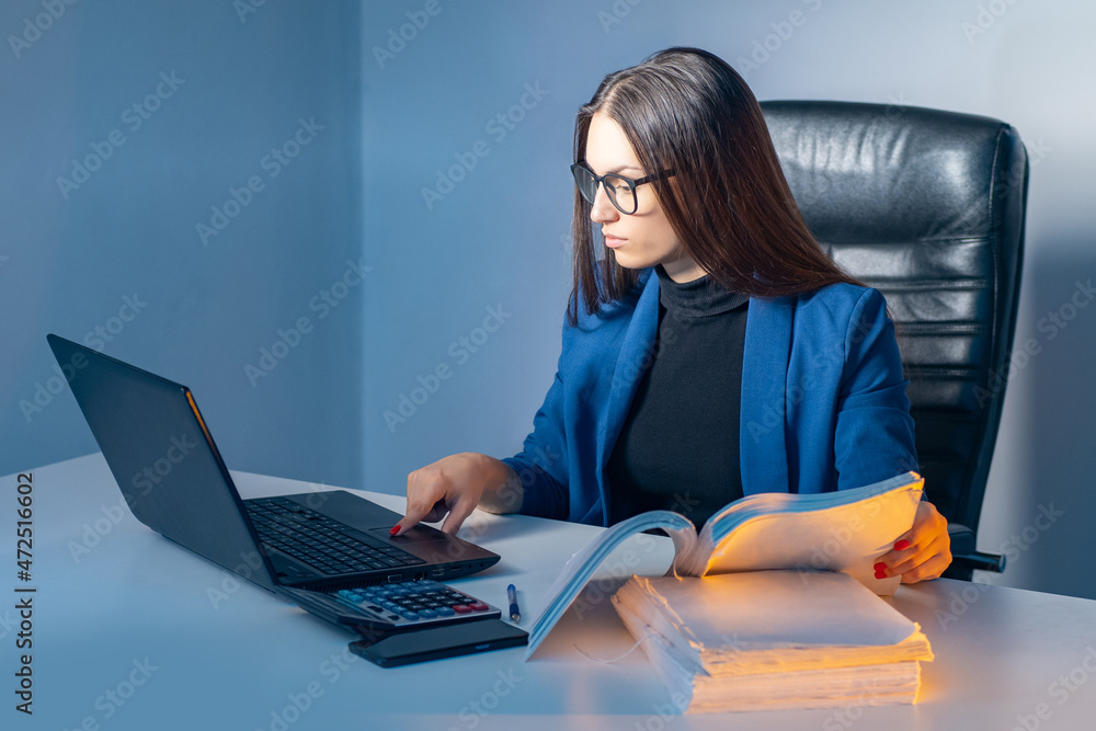 Accountant woman. Girl is engaged in paperwork. Calculator and other papers on accountant's desk. Woman is engaged in business audit. Businesswoman is sitting at computer table. Accountant career Accountant woman. Girl is engaged in paperwork. Calculator and other papers on accountant's desk. Woman is engaged in business audit. Businesswoman is sitting at computer table. Accountant career