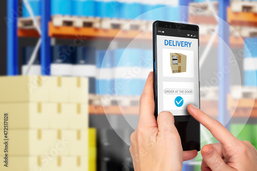 Delivery business. Sending order by courier delivery. Human hands on background of blurred warehouse. Concept - ordering from online store. Sending order to buyer's door. Apps delivery service