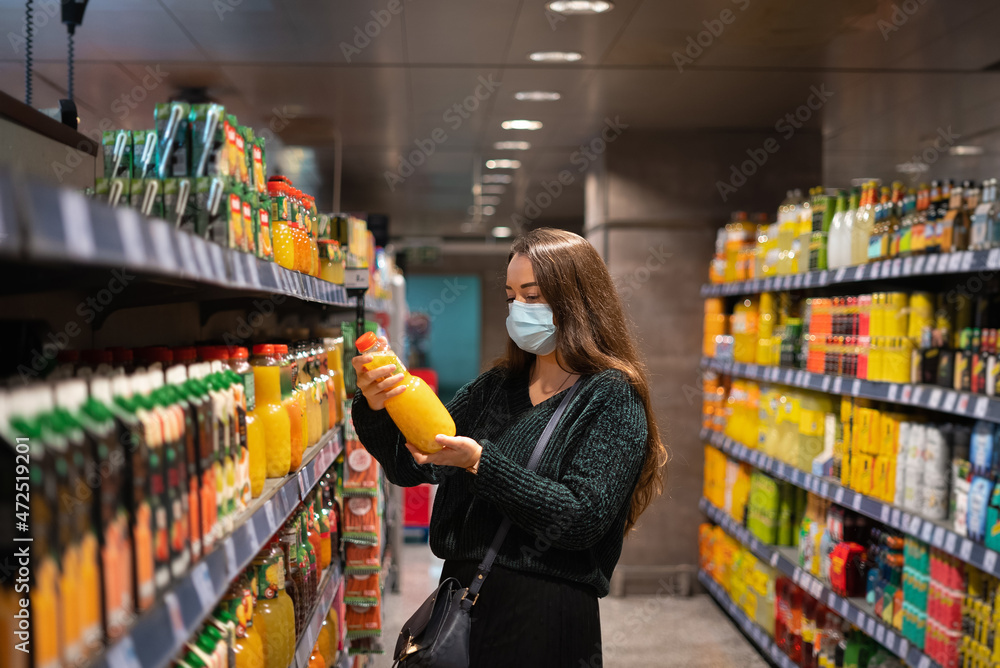 Female client buying juice in supermarket