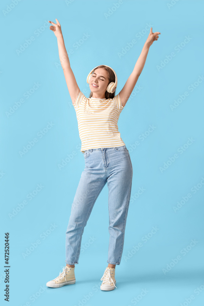 Happy young woman in headphones on blue background Happy young woman in headphones on blue background