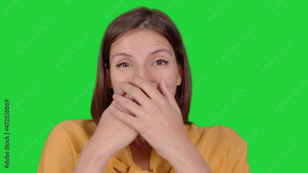 Woman being surprised and laughing. Surprised and smiling face expression of woman looking at camera. Green screen technique.