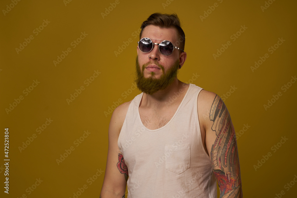 Fototapeta premium man in a white t-shirt tattoos on his arms fashion glasses modern style