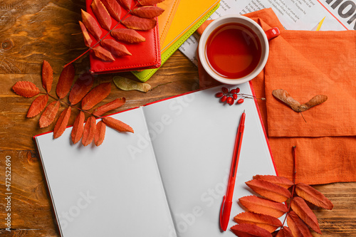 Notebooks with pen, cup of ...