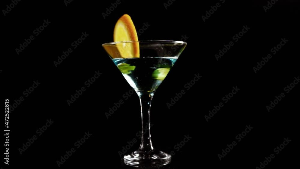 Glamorous glasses with cocktail rotate on a bar counter on a neon light Glamorous glasses with cocktail rotate on a bar counter on a neon light