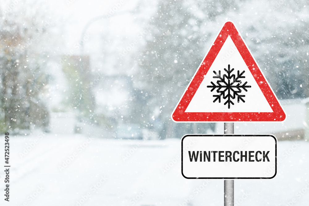 Wintercheck. Verkehrsschild mit Hinweis an einer verschneiten Straße. Wintercheck. Verkehrsschild mit Hinweis an einer verschneiten Straße.