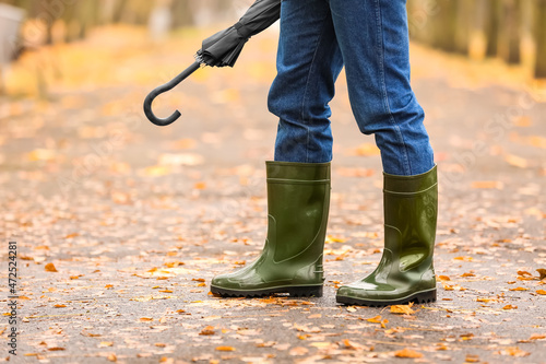 Schilderij op canvas Man wearing gumboots in park on autumn day