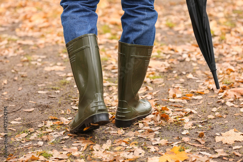 Man wearing gumboots in park on autumn day © Pixel-Shot