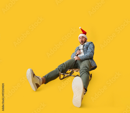 Young sledding man in Santa...
