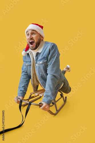 Young sledding man in Santa...