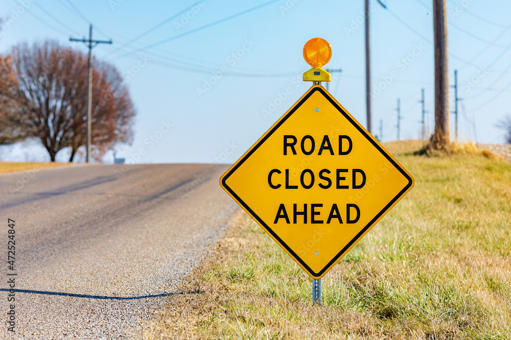 Yellow road closed ahead sign on rural road. Road construction, repair