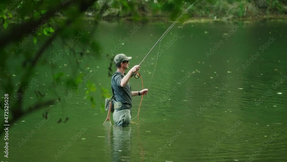Texas flyfisherman casting fly rod while wading in a beautiful green river with lush tree scenery in slow motion 4k Texas flyfisherman casting fly rod while wading in a beautiful green river with lush tree scenery in slow motion 4k