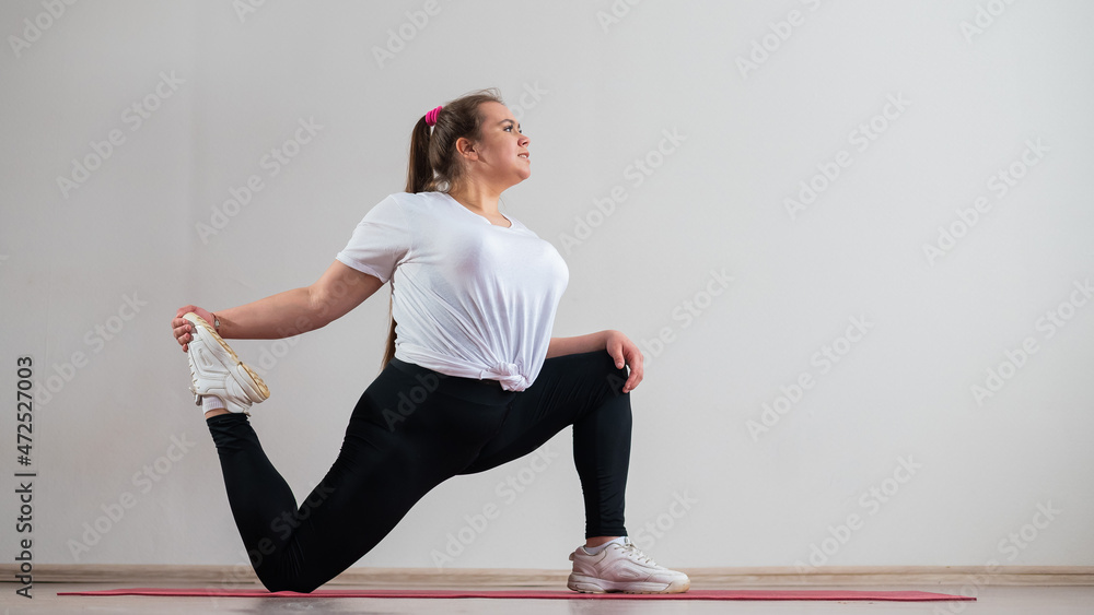 Young fat woman doing flexibility exercises on a white background