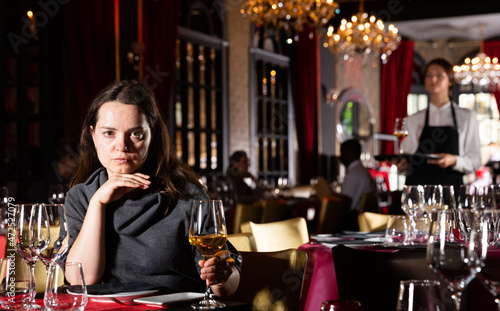 Portrait of single beautiful woman drinking wine in luxury restaurant