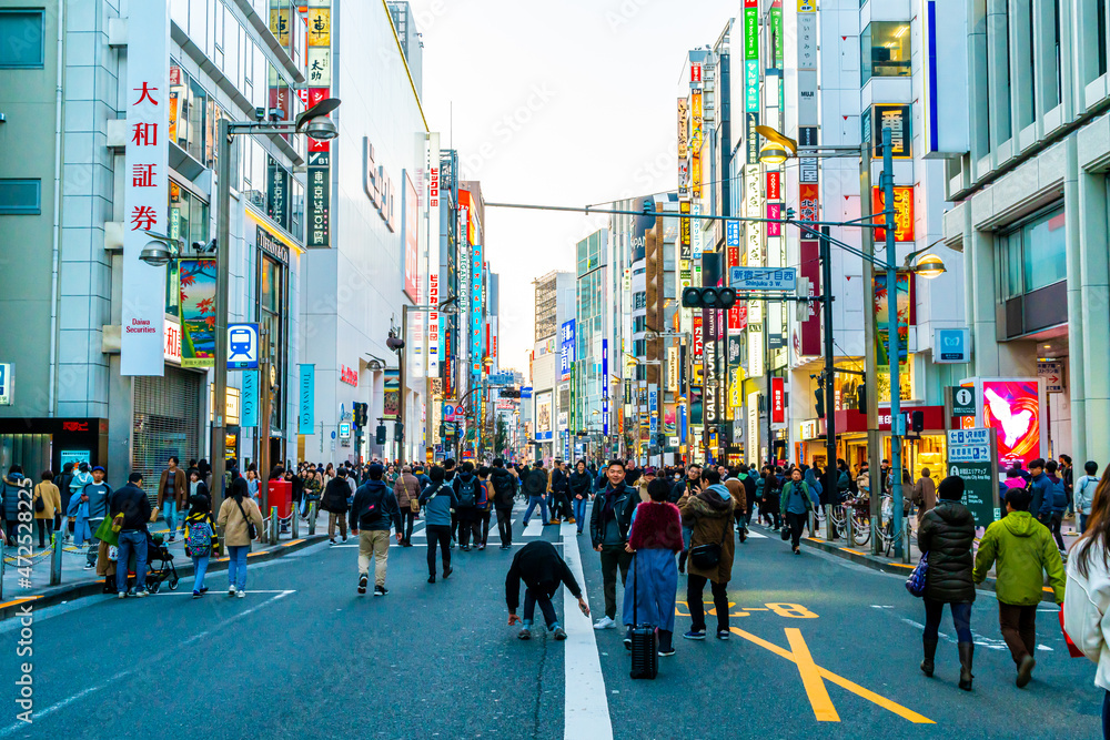 Naklejka premium TOKYO, JAPAN - Jan 13, 2020: Crowded people walking at the Shinjuku district. The area is an entertainment and shopping district in Tokyo, Japan