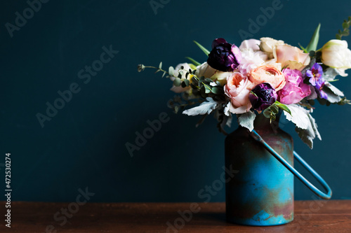 Fototapeta Naklejka Na Ścianę i Meble -  Various fresh flowers arrangement in metalic vase on wooden table