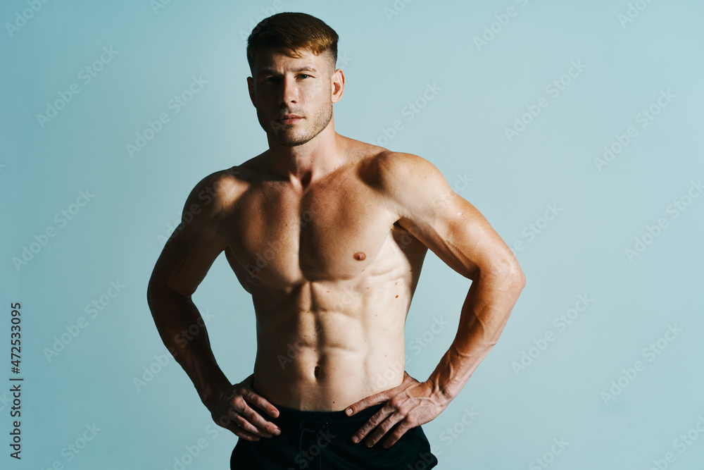 bodybuilder with muscular body posing press blue background