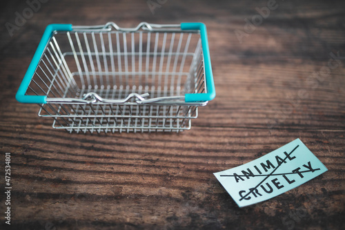 Crossed out animal cruelty product label with grocery shopping basket, healthy nutrition and ethical choices