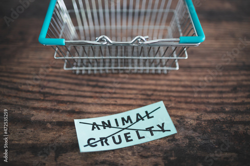 Crossed out animal cruelty product label with grocery shopping basket, healthy nutrition and ethical choices