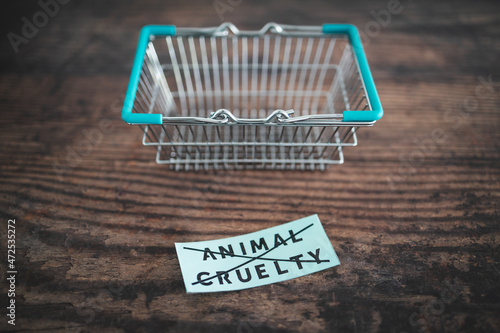 Crossed out animal cruelty product label with grocery shopping basket, healthy nutrition and ethical choices