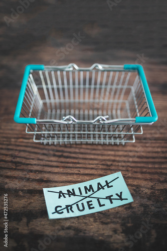 Crossed out animal cruelty product label with grocery shopping basket, healthy nutrition and ethical choices
