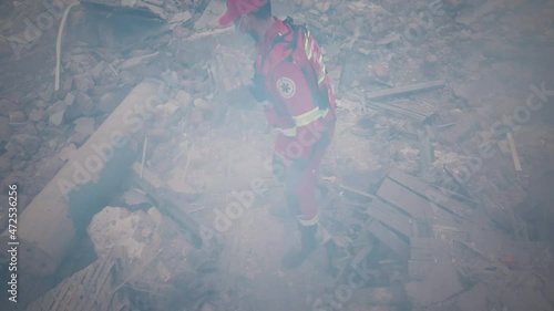 From above view of emergency service workers checking concrete rubble and searching for survivors while working on remains of broken building after earthquake