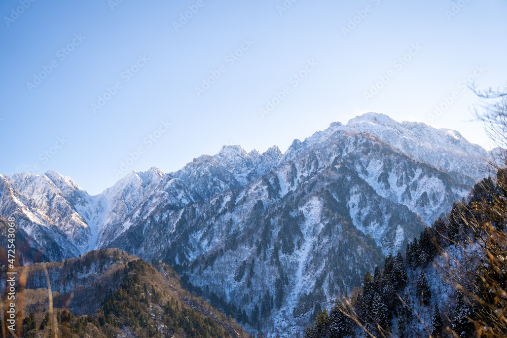 富山県立山町、上市町にある剱岳を見るために雪が積もる冬の中山を登山する風景 A view of climbing a mountain in winter with snow to see Tsurugidake in Tateyama and Kamiichi towns, Toyama Prefecture.