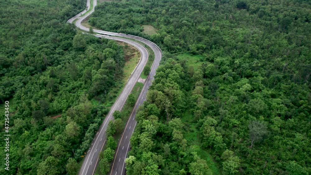 Top view of countryside road passing through the green forrest and mountain Top view of countryside road passing through the green forrest and mountain