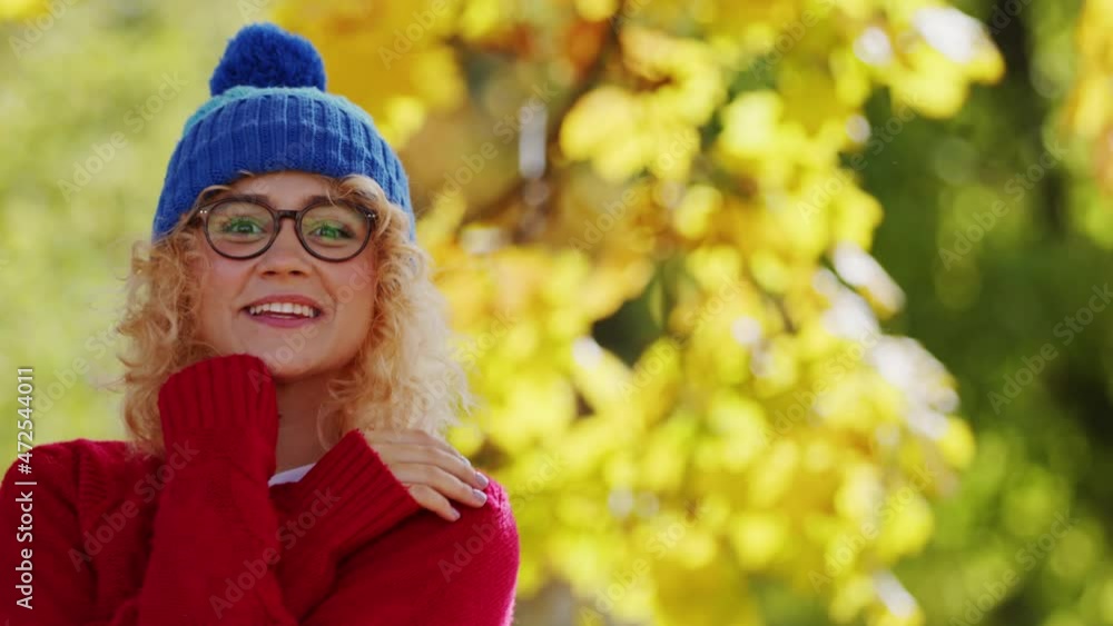 Woman smiling and happy with her blue beanie hat and red sweatshirt for the winter Woman smiling and happy with her blue beanie hat and red sweatshirt for the winter