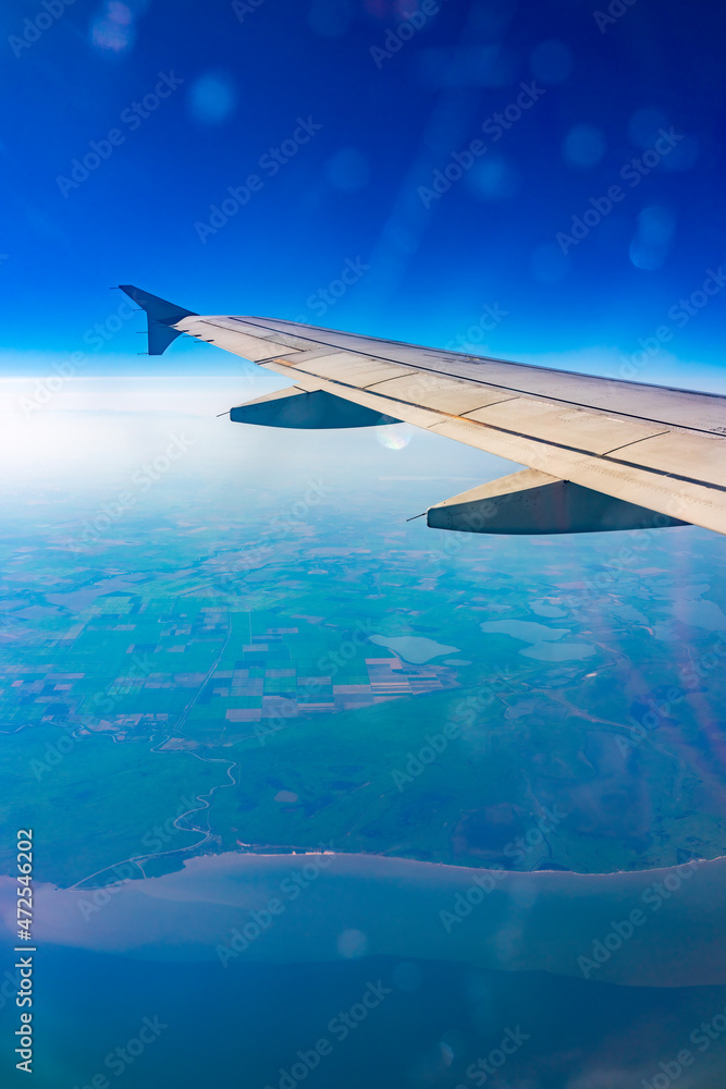 View from the airplane window at a beautiful blue clear sky and the airplane wing