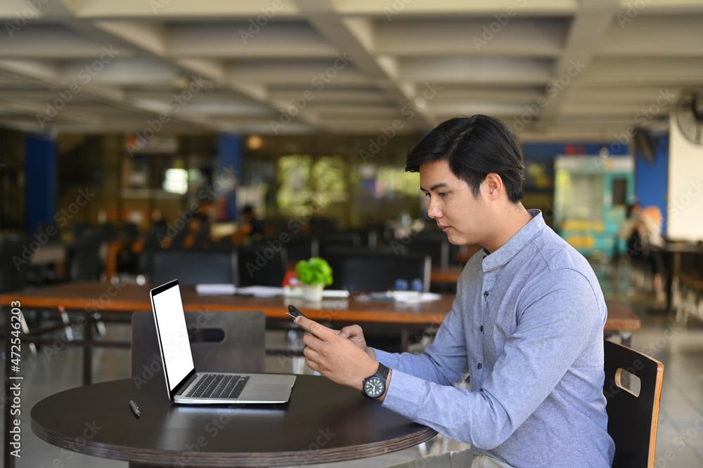 Asian businessman sitting in office and using smart phone. Asian businessman sitting in office and using smart phone.
