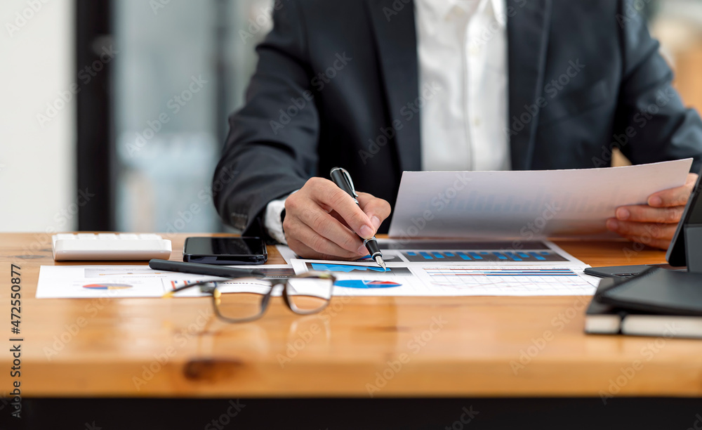 businessman working at office with document on his desk, doing planning analyzing the financial report, business plan investment, finance analysis concept. businessman working at office with document on his desk, doing planning analyzing the financial report, business plan investment, finance analysis concept.