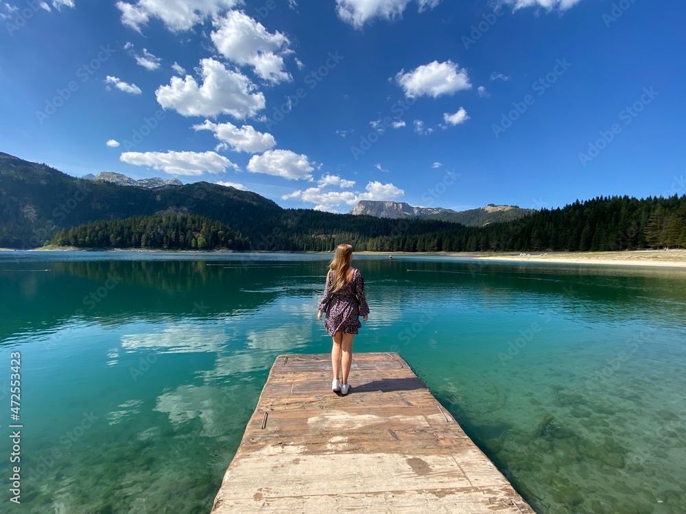 Beauty of nature and person, A girl standing on the bridge with Amaizing view on Durmitor lake and mountains, National Park, Mediterranean, Montenegro. Beauty of nature and person, A girl standing on the bridge with Amaizing view on Durmitor lake and mountains, National Park, Mediterranean, Montenegro.
