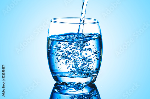 Mineral water background. Pouring water into glass. Drinking water fizzy bubble. Sparkling water glass.