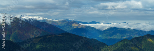 Aerial view above the clouds in mountain valley at morning. Wide banner